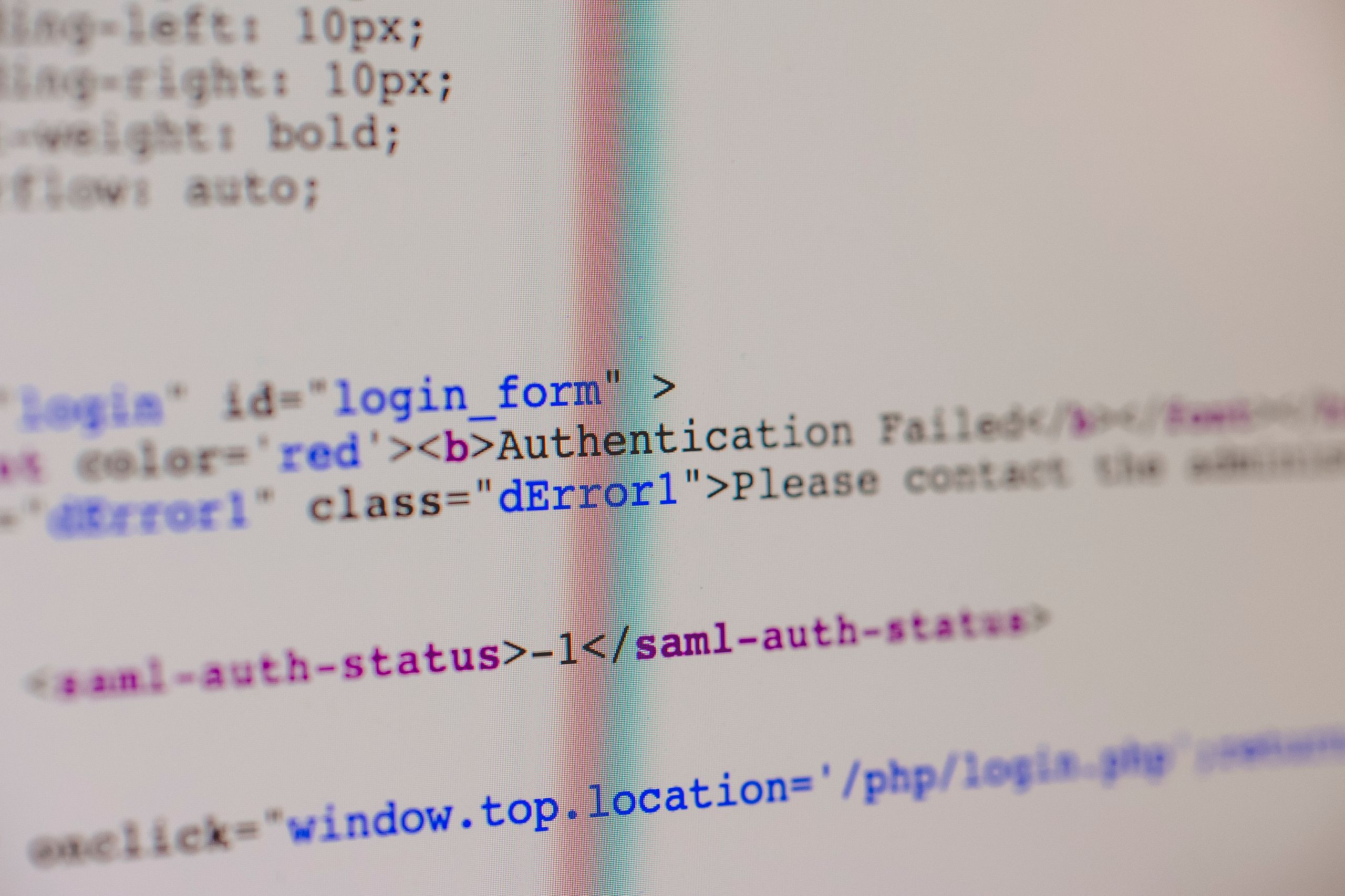 Close-up of HTML and PHP code on screen showing error message and login form data.